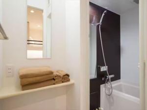 a bathroom with a mirror and towels on a shelf at Chaan Ueno Hotel - Vacation STAY 01162v in Tokyo +23 photos