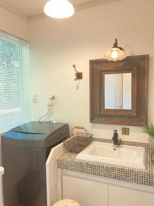 une salle de bain avec une baignoire, un lavabo et un miroir dans l'établissement Cottage Dejavu & Harvest - Vacation STAY 03241v, à Uwano 10 autres photos