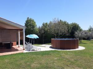 a hot tub and an umbrella in a yard at Charming Pool Home Near Pula in Pula