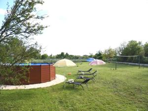 two picnic tables and umbrellas in a park at Charming Pool Home Near Pula in Pula +16 photos