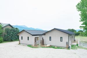 a white house with a black roof at Green Peak - Vacation STAY 05851v in Minami Aso