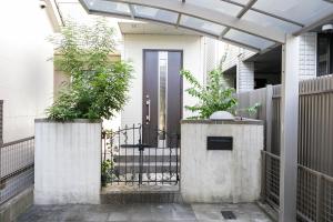 a front door of a house with two potted plants at HANA - Vacation STAY 18403 in Nagoya
