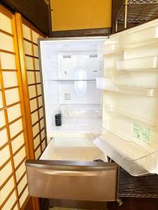 ein leerer Kühlschrank mit offener Tür in einem Raum in der Unterkunft Hakusanjinjya Santokukan - Vacation STAY 18679 in Takasaki