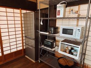 eine Küche mit Kühlschrank und Mikrowelle in der Unterkunft Hakusanjinjya Santokukan - Vacation STAY 18679 in Takasaki