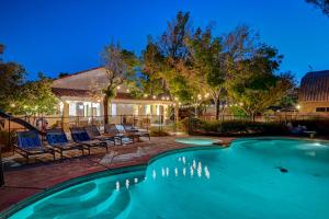 ラスベガスにあるLuxury 6 BR Home Large Pool & Spa with Grassy Yardの椅子と家のあるプール