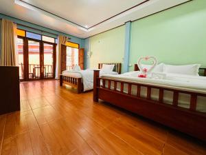 a bedroom with two beds and a wooden floor at Bangalow Coconut corner in Ban Laem Sai