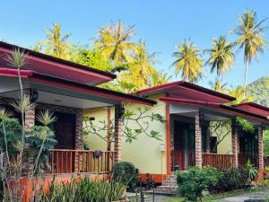 a house with palm trees in the background at Bangalow Coconut corner in Ban Laem Sai