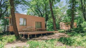 a house sitting in the middle of a forest at Snow Peak LAND STATION HAKUBA - Vacation STAY 12869v in Hakuba
