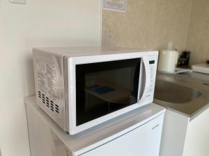 a microwave oven sitting on top of a kitchen counter at THE LAND HOTEL - Vacation STAY 16151v in Arao