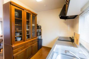 a kitchen with a wooden cabinet and a sink at ObihiroINN - Vacation STAY 18480 in Obihiro +15 photos