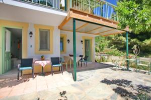 a patio with chairs and a table and a balcony at Pelagos in Stafylos