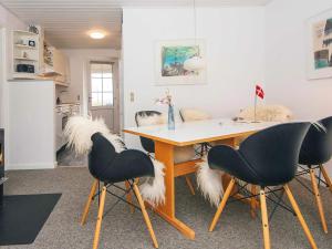 a dining room with a table with two chairs with faux fur at 4 star holiday home in Lemvig in Lemvig