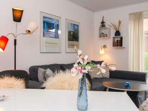 a living room with a vase of flowers on a table at 4 star holiday home in Lemvig in Lemvig +30 photos