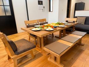 a wooden dining room table with plates of food on it at Machinakanoie Mana - Vacation STAY 16638v in Ishigaki Island