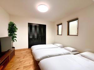 a room with four beds and a flat screen tv at Machinakanoie Mana - Vacation STAY 16638v in Ishigaki Island