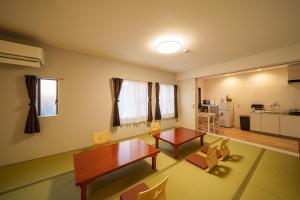 a living room with a table and chairs and a kitchen at Yufuin Sora - Vacation STAY 23008v in Yufuin