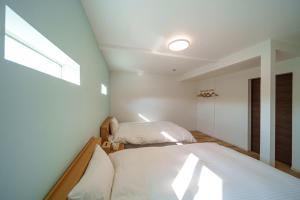 two beds in a small room with a window at Yufuin Sora - Vacation STAY 23008v in Yufuin