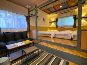 ein Wohnzimmer mit einem Sofa und 2 Betten in der Unterkunft Hyuga Surf Camp 105 - Vacation STAY 29665v in Hyuga