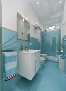 a blue bathroom with a sink and a toilet at Case Della Baia in Castellammare del Golfo