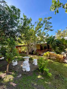 a garden with white statues in front of a house at Villagracia Homestay in Mambajao