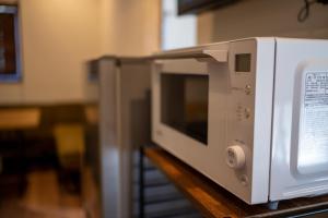 un four micro-ondes blanc assis au-dessus d'un comptoir dans l'établissement Hyuga Surf Camp111 - Vacation STAY 29792v, à Hyuga