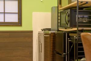 a kitchen with a microwave and a tv on a counter at Hyuga Surf Camp102 - Vacation STAY 31830v in Hyuga