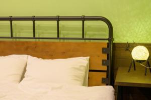 a bed with a metal headboard and a table with a lamp at Hyuga Surf Camp102 - Vacation STAY 31830v in Hyuga