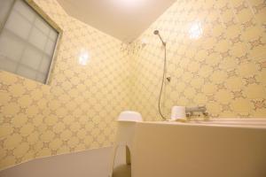a bathroom with yellow wallpaper and a sink and a shower at Hyuga Surf Camp102 - Vacation STAY 31830v in Hyuga +19 photos