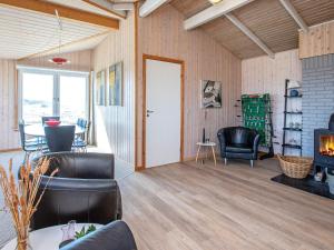a living room with leather chairs and a fireplace at 4 star holiday home in Lemvig in Ferring