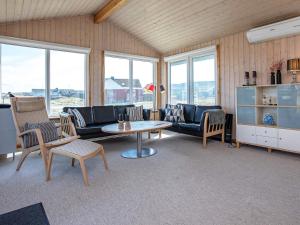 a living room with a couch and a table and chairs at 4 star holiday home in Lemvig in Ferring