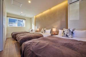 ein Hotelzimmer mit drei Betten und einem Fenster in der Unterkunft Fuji Kurasu Heart - Vacation STAY 19613v in Azagawa