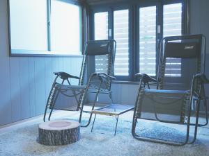 3 Stühle neben einem Baumstumpf in einem Zimmer in der Unterkunft SAUNA&CURRY URI HIGASHIOSAKA - Vacation STAY 21491v in Osaka