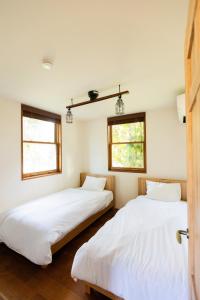 two beds in a room with two windows at Cardiff-Kujukuri- - Vacation STAY 48763v in Kujukuri