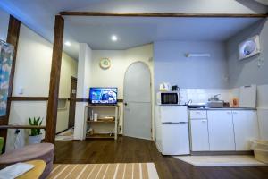 a kitchen with a white refrigerator and a microwave at Hyuga Surf Camp 212 - Vacation STAY 35446v in Hyuga