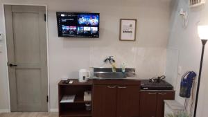 a kitchen with a sink and a tv on the wall at Hyuga Surf Camp 210 - Vacation STAY 35366v in Hyuga