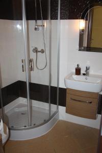 a bathroom with a shower and a sink at Apartamenty Sokółka in Sokółka +21 photos