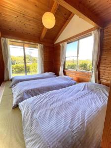 two beds in a room with two windows at Gubo Satoyama Suite Lodge & Camp - Vacation STAY 39506v in Katsuura +14 photos