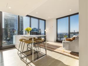 a kitchen with a bar with stools and large windows at Matilda's Skyview - Luxe 2BR, 2BA Near Crown in Melbourne