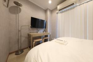 ein Schlafzimmer mit einem Bett und einem TV auf einem Tisch in der Unterkunft Shiono Building - Vacation STAY 43324v in Yagisawa