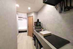 eine Küche mit Spüle und Mikrowelle in der Unterkunft Shiono Building - Vacation STAY 43324v in Yagisawa