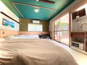 a bedroom with a large bed with a blue ceiling at Hyuga Surf Camp106 - Vacation STAY 29716v in Hyuga