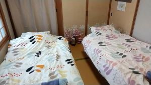 two beds sitting next to each other in a room at M&Y House - Vacation STAY 31586v in Hakodate