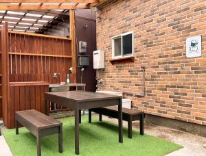 a picnic table and benches in front of a brick wall at Hyuga Surf Camp112 - Vacation STAY 31765v in Hyuga