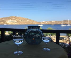 two wine glasses sitting on a table with a vase at Asteri Hotel in Livadi