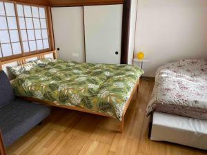 a bedroom with a bed and a couch in it at Guest House Wakamizu - Vacation STAY 18625 in Koga