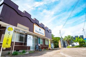 un bâtiment violet avec un panneau devant dans l'établissement Hyuga Surf Camp202 - Vacation STAY 31884v, à Hyuga