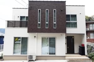 a white house with a black roof at Hikarinoyado Yamate - Vacation STAY 18639 in Sasebo