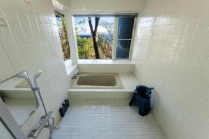une salle de bain avec une baignoire et une fenêtre dans l'établissement AZUR Izu Atagawa aurora - Vacation STAY 31844v, à Okawa 50 autres photos