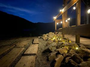 a wooden deck with rocks and lights at night at La Cachette - Vacation STAY 45323v in Ina