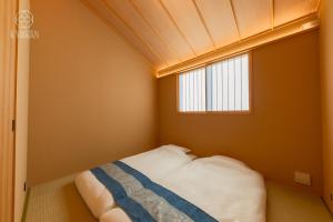 a small bedroom with a bed with a window at Kyoran Hayashi House, Aoumi - Vacation STAY 53463v in Gionmachi